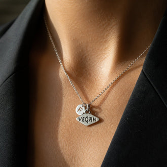 Personalized vegan necklace on model, sterling silver custom charm jewelry close-up photo