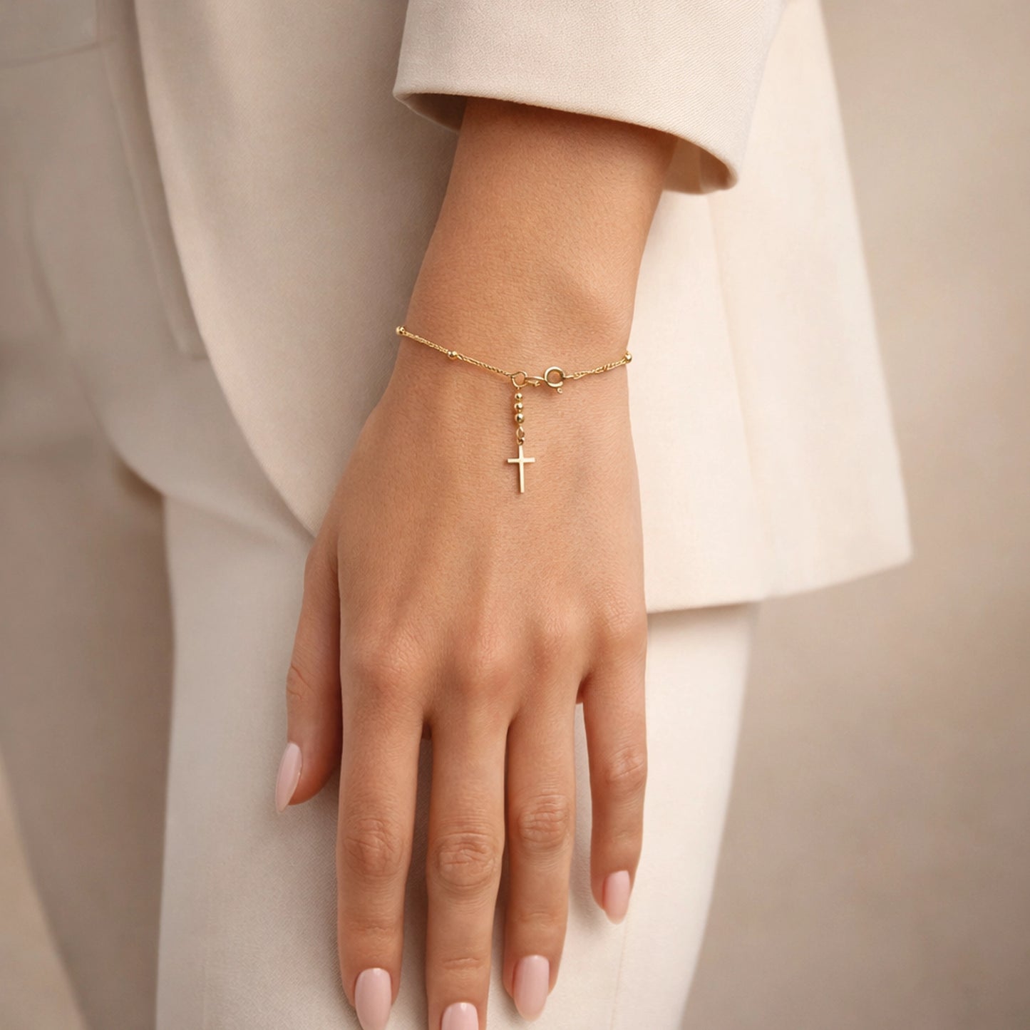18K gold filled cross bracelet on delicate chain with dangling cross charm, worn on elegant female hand with nude manicure, minimalist studio background, Christian dainty faith jewelry for women