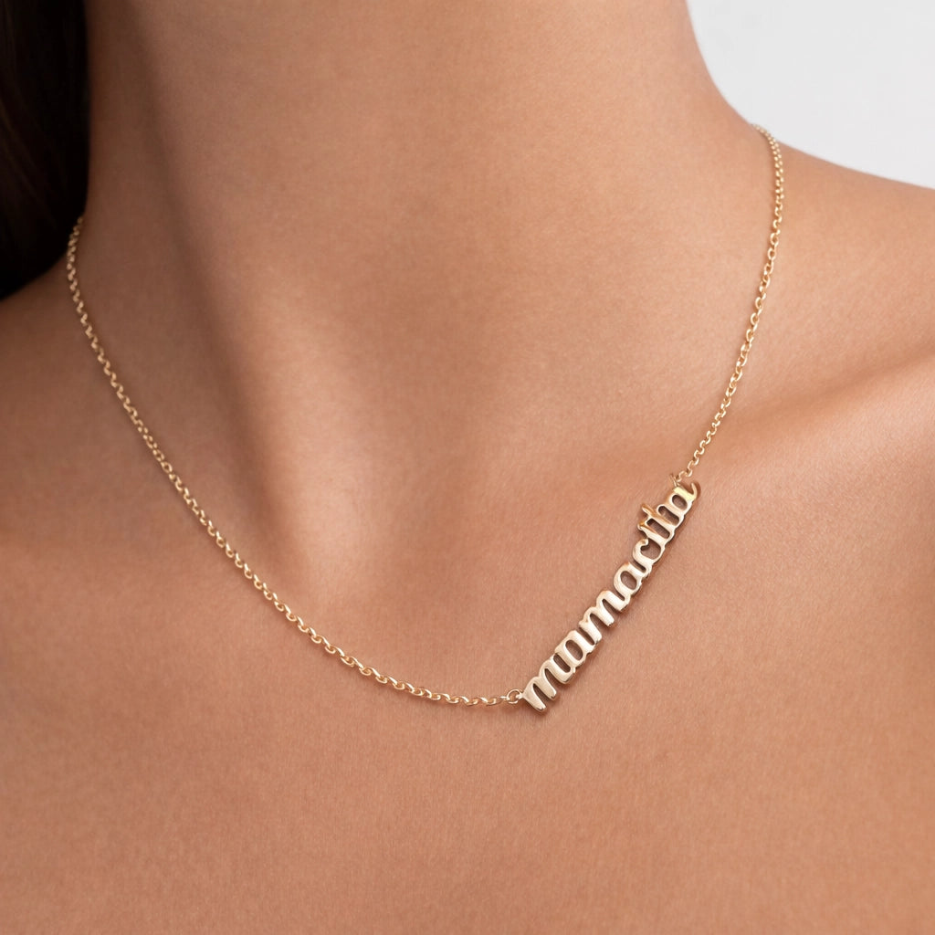 Gold filled “mamacita” name necklace on a delicate cable chain, minimalist script pendant, gold name jewelry, dainty everyday necklace for women, close-up studio shot on natural skin.