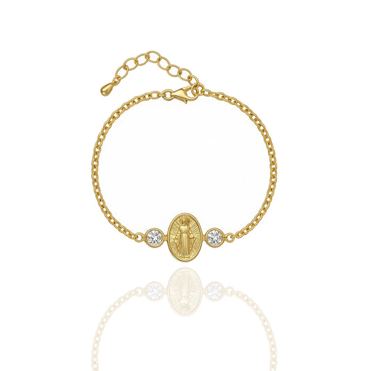 18K gold filled Virgin Mary bracelet with an oval Our Lady of Grace charm flanked by two bezel-set cubic zirconia accents, shown against a white background with a soft mirrored reflection.