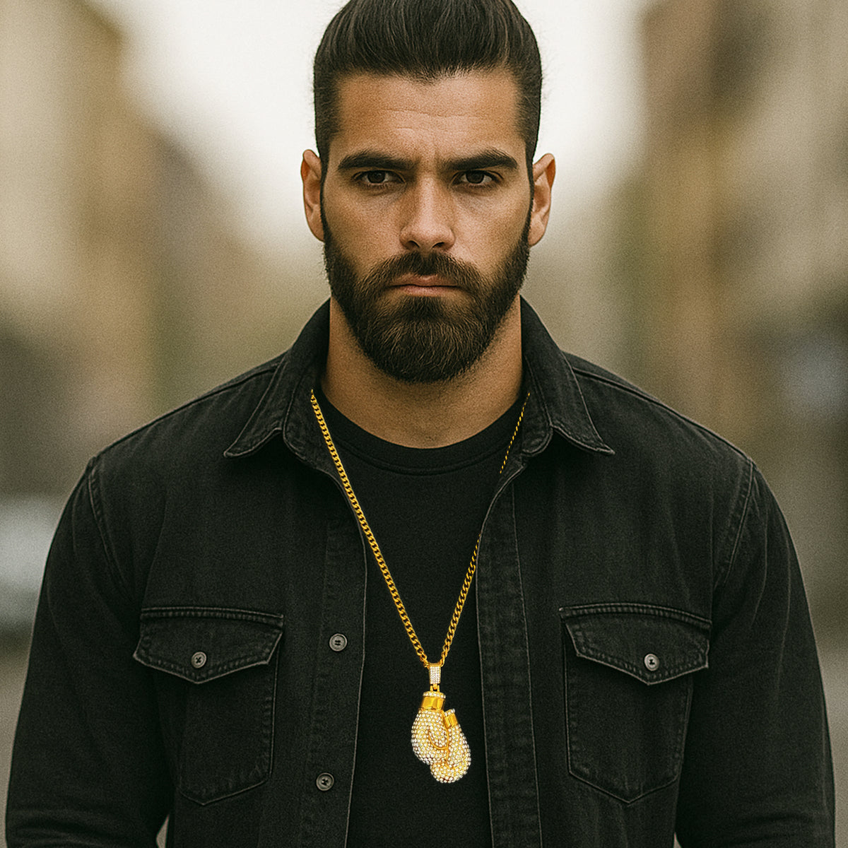 Man wearing black denim shirt with gold CZ boxing glove pendant necklace, hip hop street style look