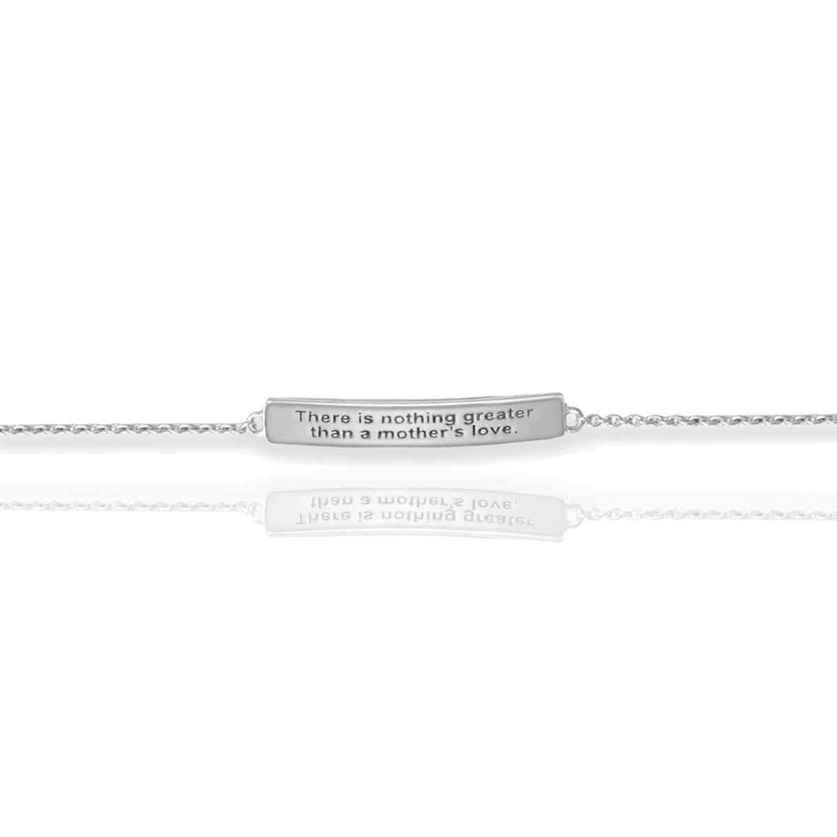 Close-up of engraved silver bar with the phrase "There is nothing greater than a mother’s love", reflecting softly on a clean white surface.