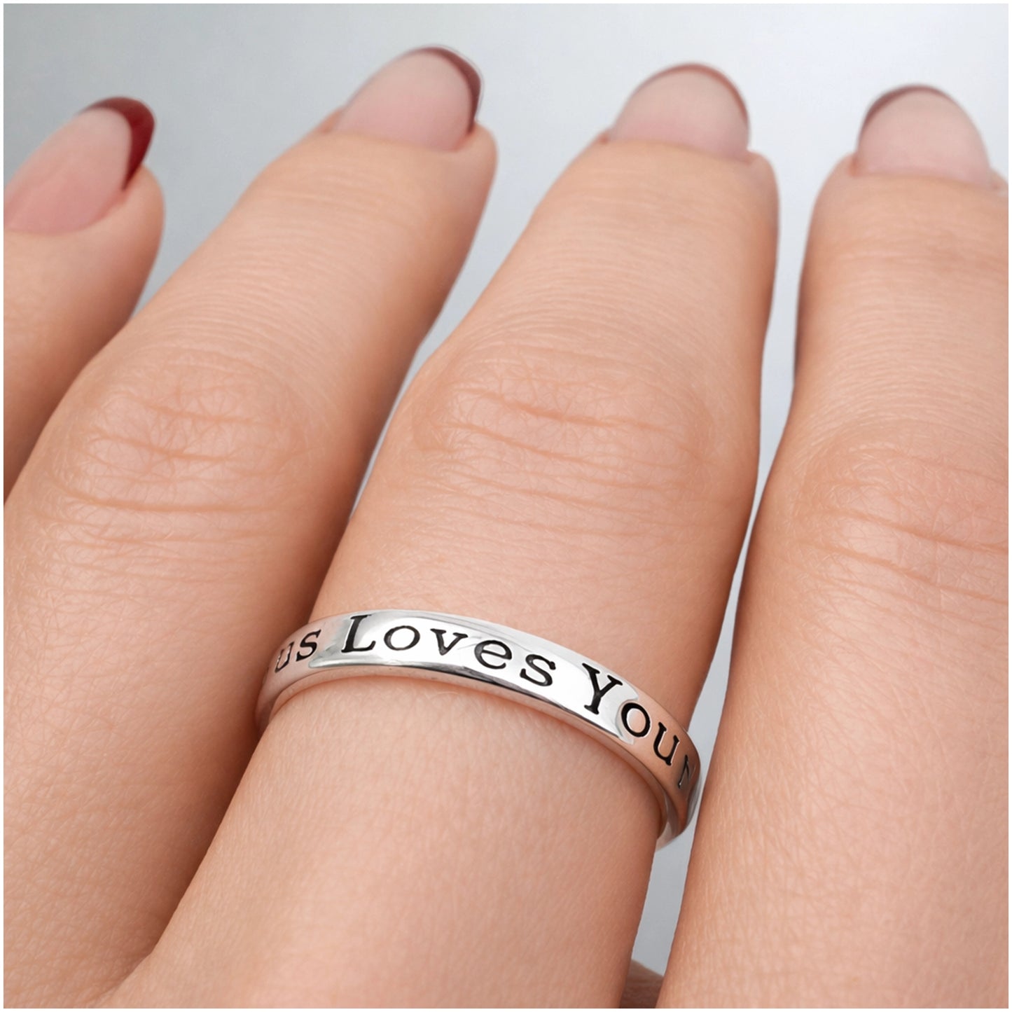 Christian engraved silver ring for women featuring “Jesus Loves You” message and small cross, inspirational faith jewelry close-up