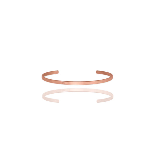 Tiny copper cuff bracelet on a white background