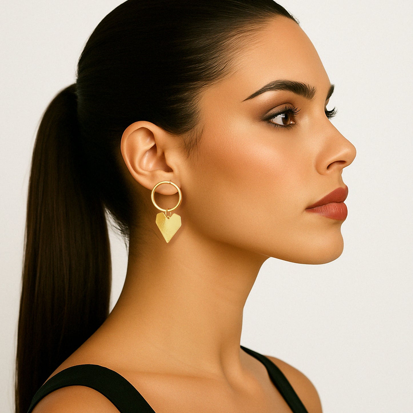 Pendientes de botón con forma de corazón dorado, cadena con clip y diseño circular desigual.