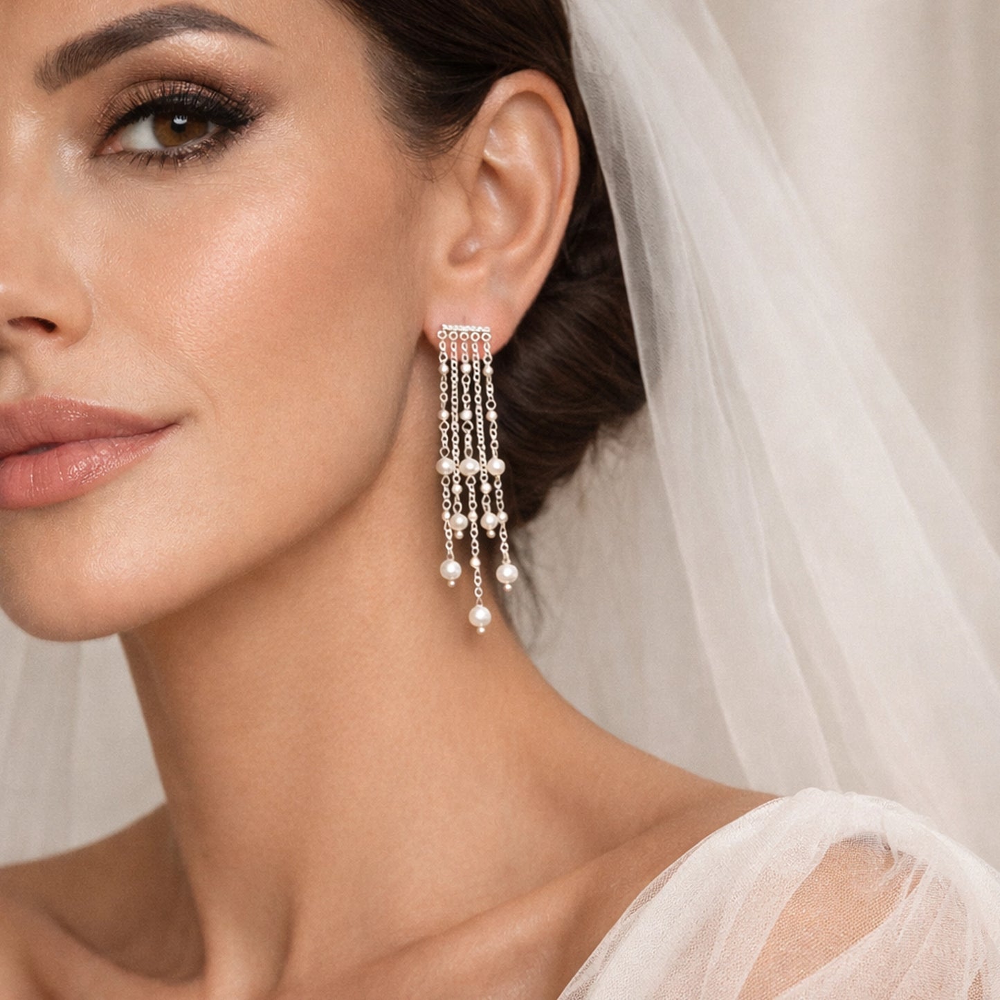Bridal pearl chain chandelier earring on modern bride, long cascading pearl strands, elegant wedding jewelry, statement bridal earrings, luxury bride portrait with veil, delicate pearl drop earring close-up, sophisticated wedding accessory for bride.
