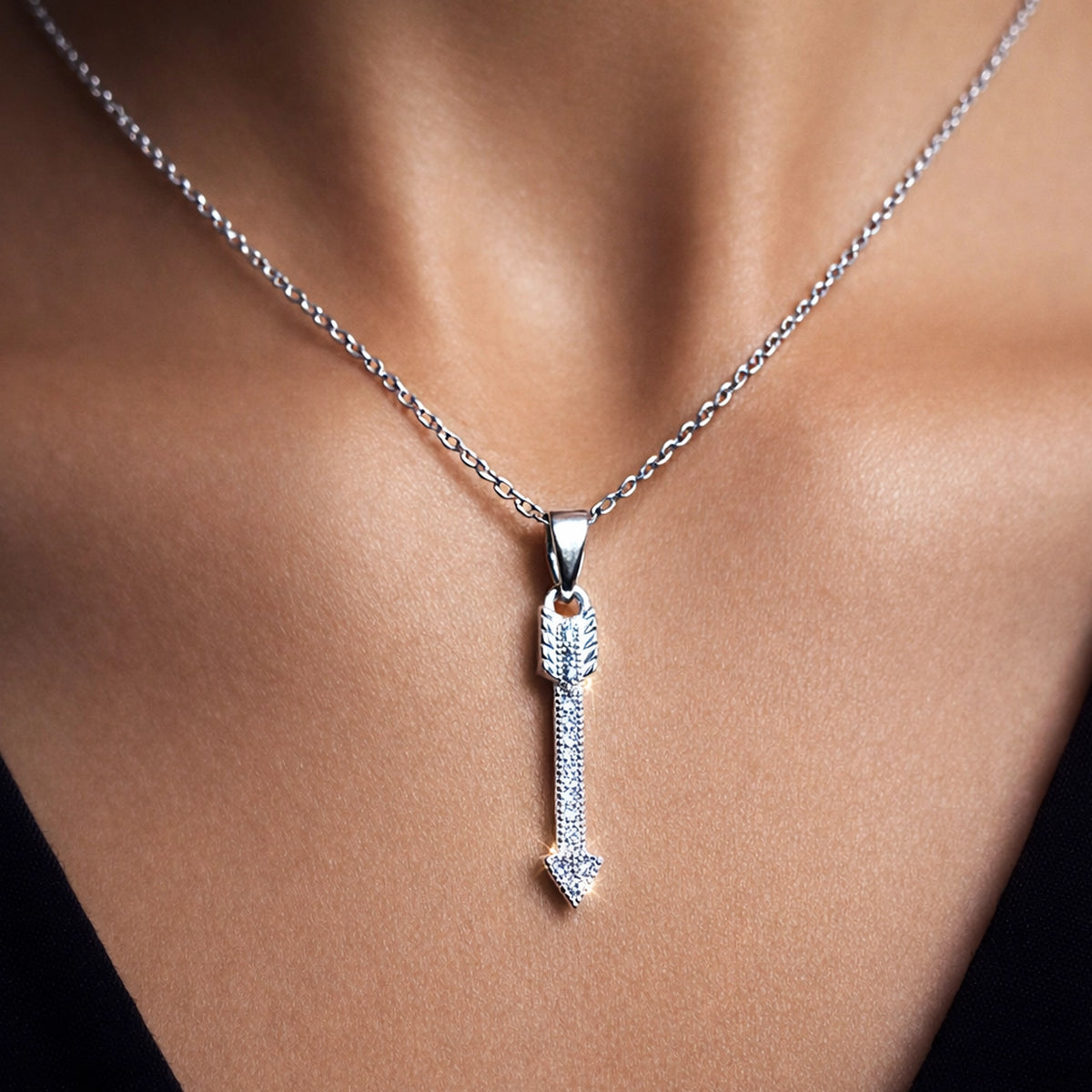Sterling silver arrow pendant necklace on cable chain, pavé CZ arrow charm, minimalist dainty jewelry close-up on model, elegant everyday necklace gift for her