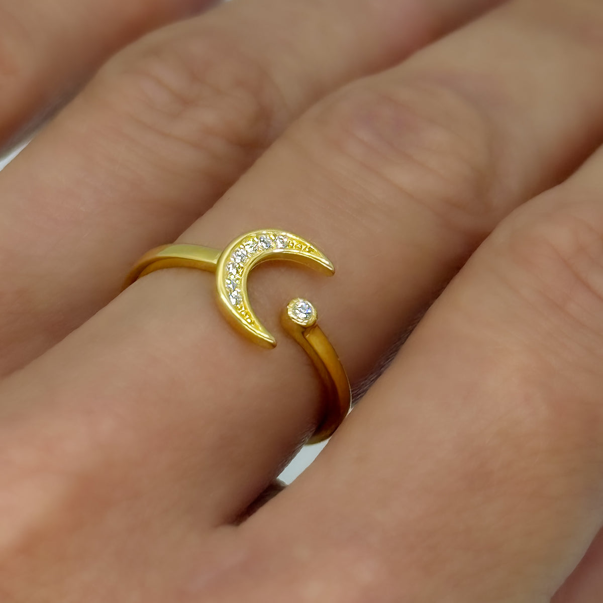 Yellow gold-plated sterling silver ring featuring a sparkling CZ crescent moon and star motif. Adjustable and lightweight, worn on the finger for a delicate celestial look.