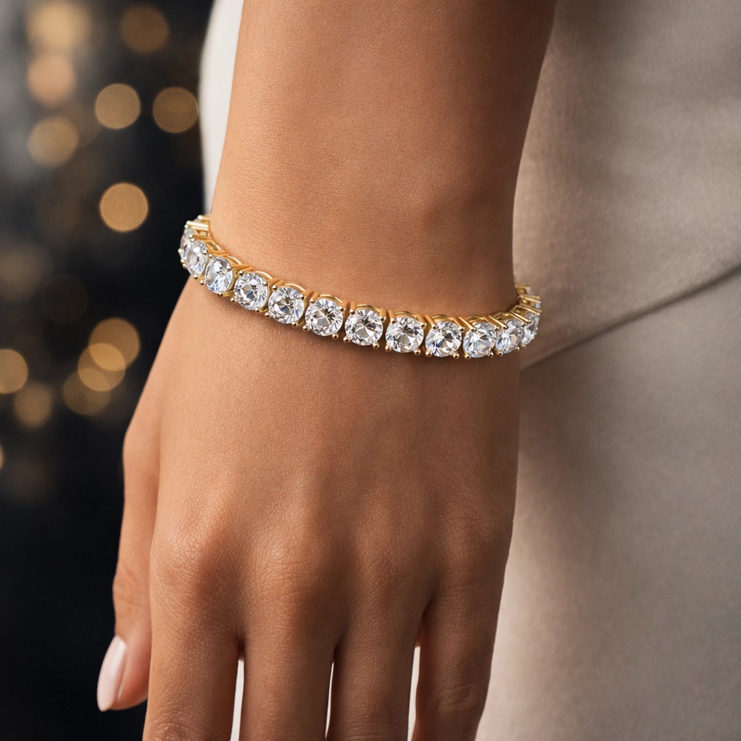 Luxury gold tennis bracelet with round brilliant cubic zirconia stones on a stylish woman’s wrist, close-up, professional lighting, elegant background, high-resolution