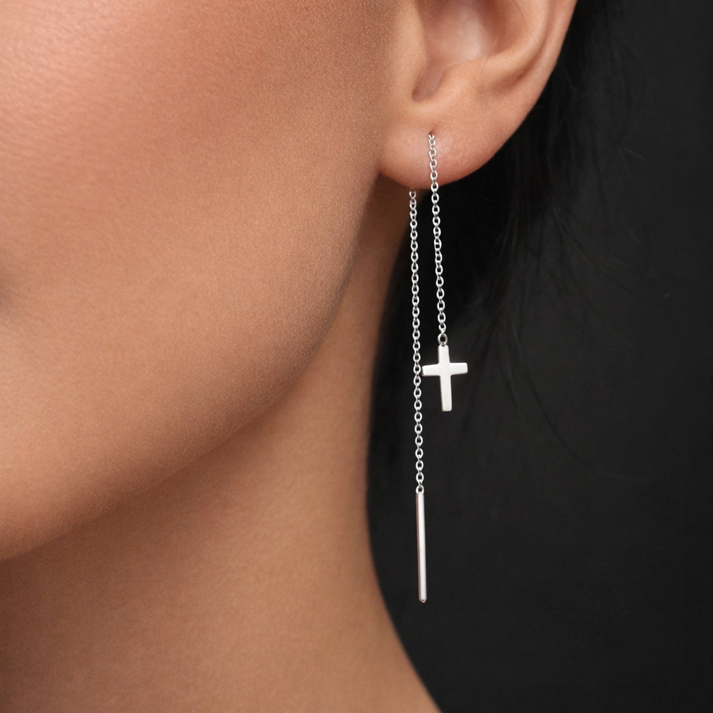 Sterling silver cross threader earrings with delicate chain drop and long bar stick detail, styled on a model in close-up with professional studio lighting, highlighting the minimalist Christian cross charm and sleek modern dangle design.