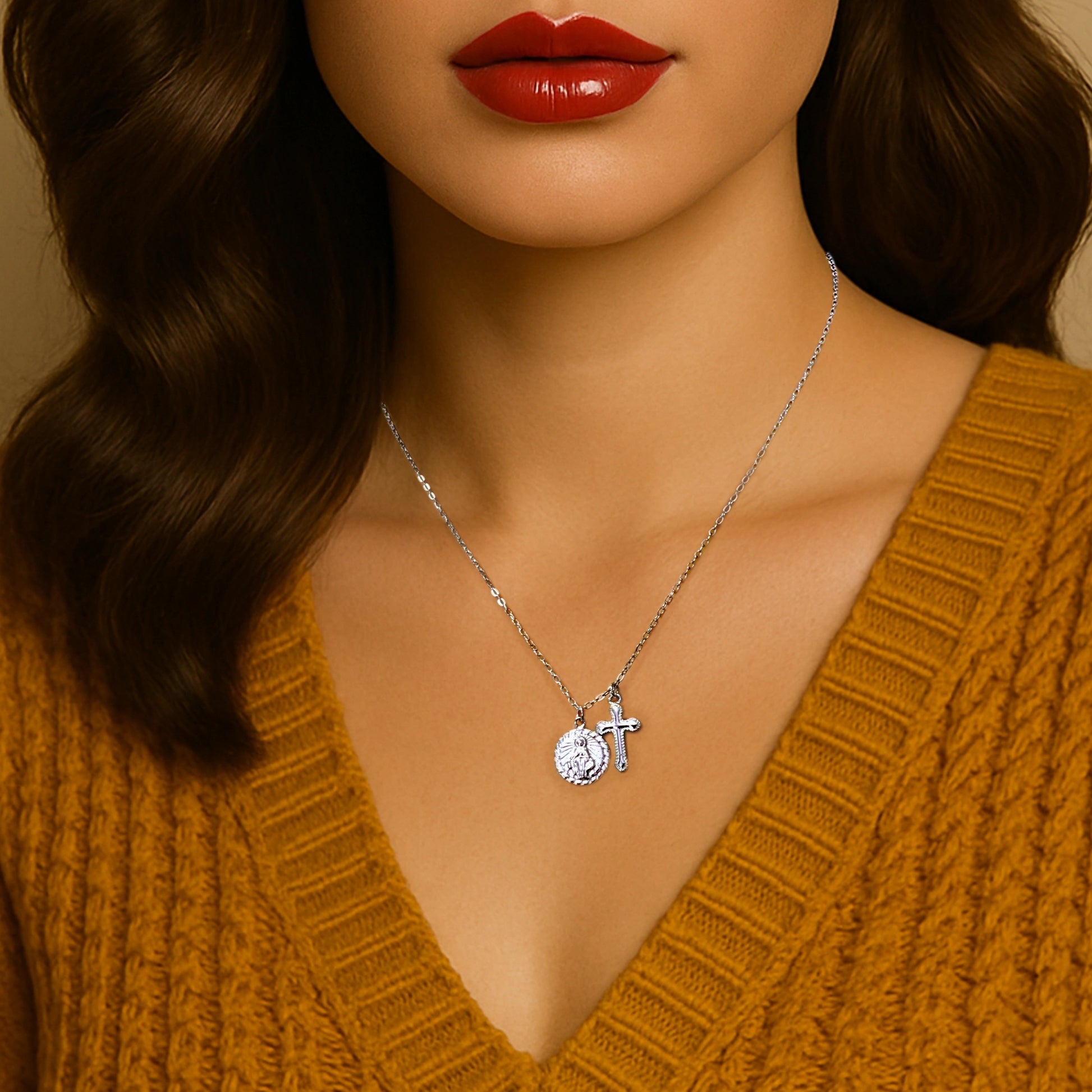 Woman in mustard knit sweater wearing a dainty sterling silver Virgin Mary and cross charm necklace