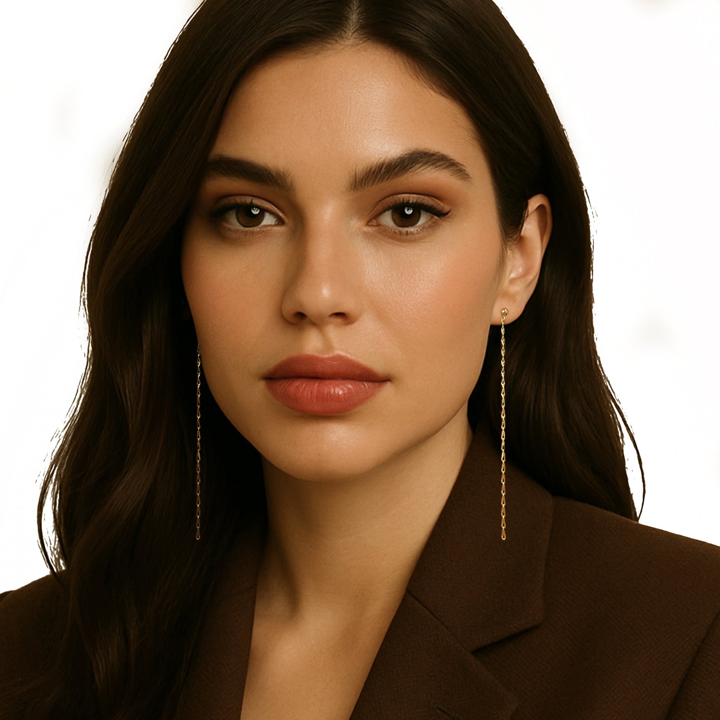 Elegant woman in a brown blazer wearing minimalist extra-long linear drop earrings in gold filled, featuring a delicate chain design that adds a refined, elongated silhouette to her polished look.