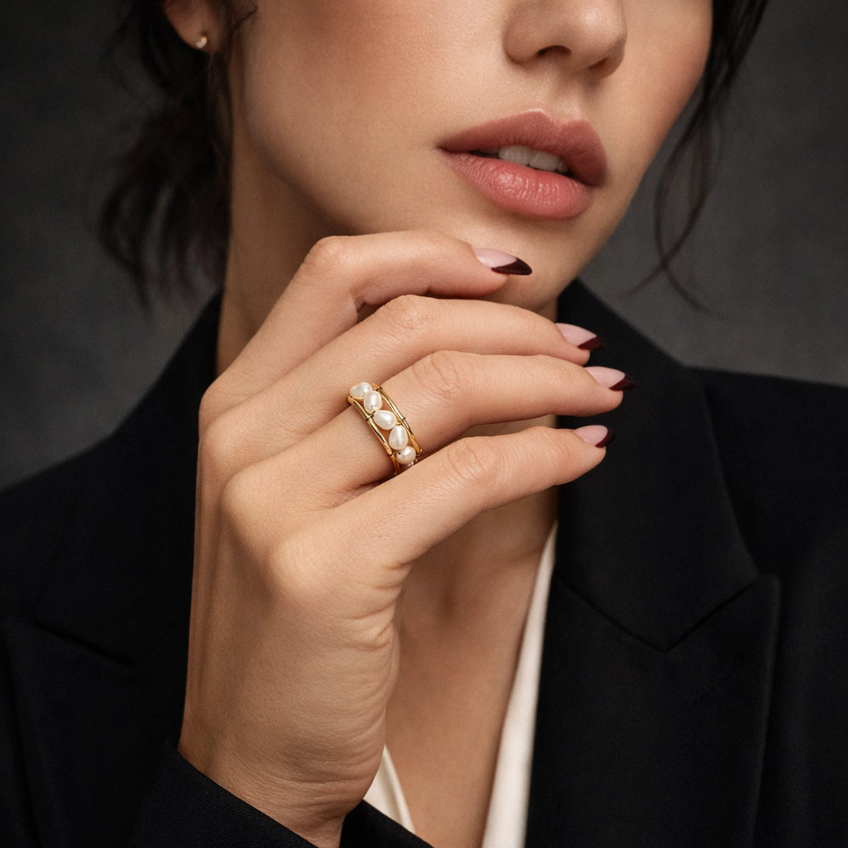 Elegant gold pearl ring with natural baroque pearls on a woman's hand, close-up fashion portrait with glossy lips and stylish manicure, showcasing a delicate statement ring.