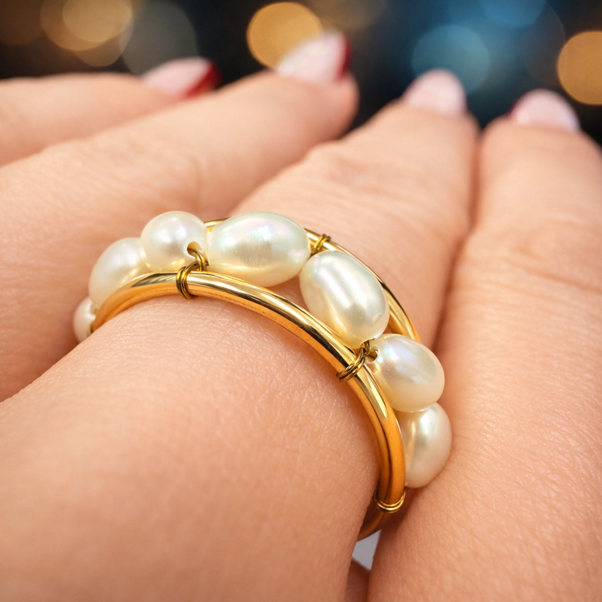 white pearl wire-wrapped ring in 18k gold plated brass wire band, elegant handmade pearl stacking ring on model’s hand with soft bokeh background, minimalist bridal or everyday jewelry