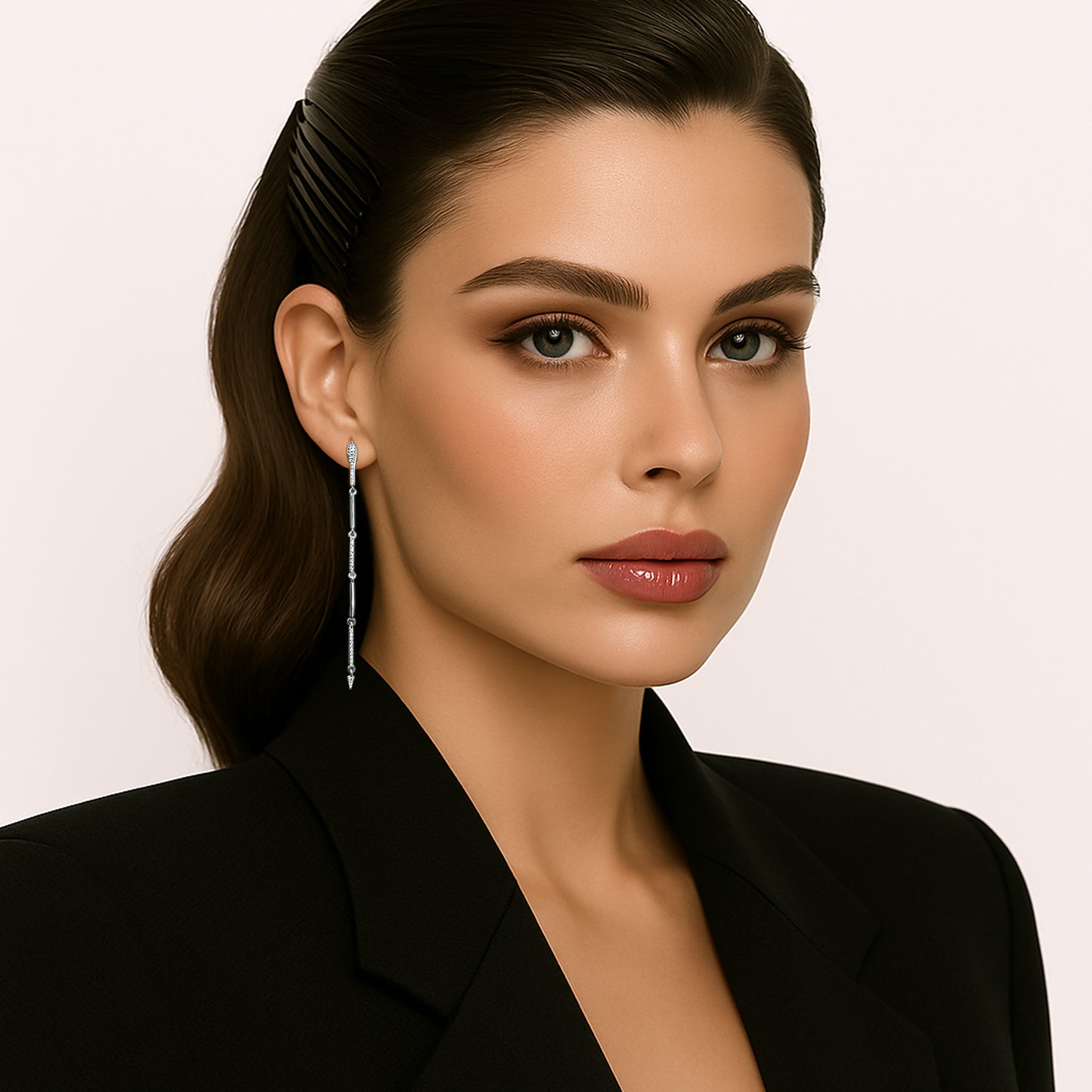 Elegant woman wearing long snake bar earrings in sterling silver with cubic zirconia, styled with a sleek black blazer and neatly pinned hair.