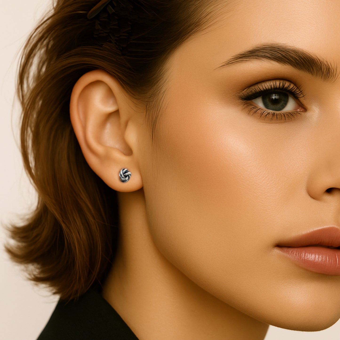 Minimalist everyday sterling silver knot earrings showcased on a woman’s ear, highlighting their petite and elegant design.