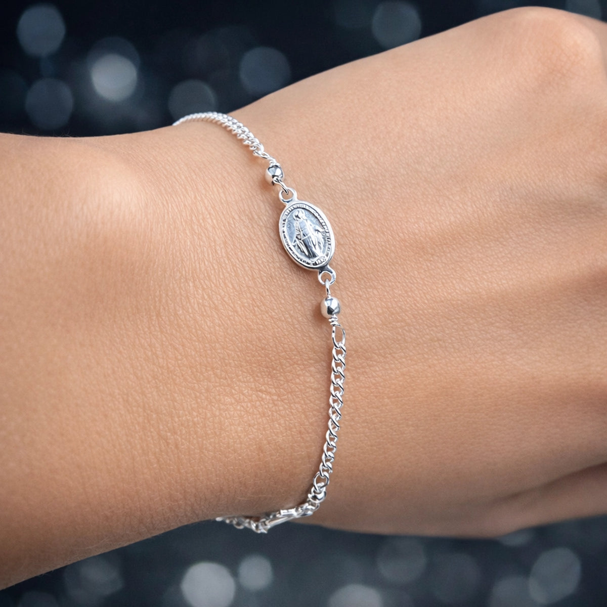 Sterling silver Virgin Mary medallion bracelet on delicate chain, minimalist religious charm bracelet worn on wrist, dainty Catholic jewelry gift for her, everyday faith bracelet with polished silver finish.