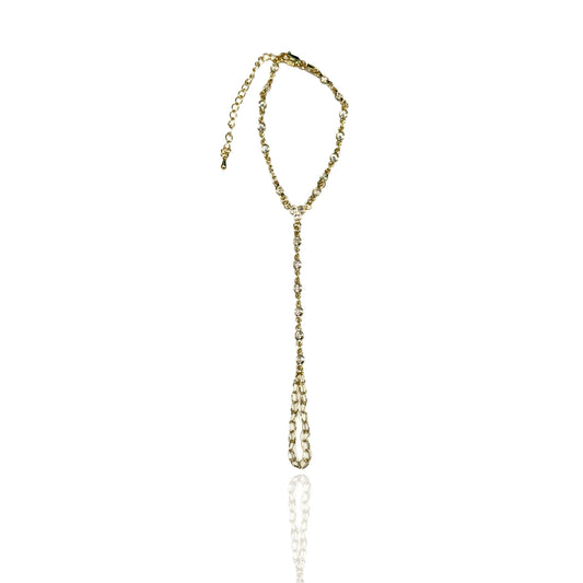 Elegant gold filled hand chain with sparkling CZ stones laid flat on a white background, highlighting the minimalist design and structure.