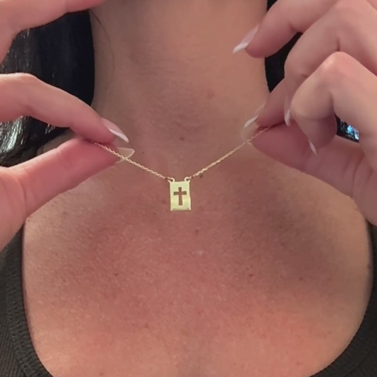 Gold-filled cross tag necklace video highlighting the sleek rectangular pendant with a cut-out cross design, displayed on a delicate chain with subtle shine.
