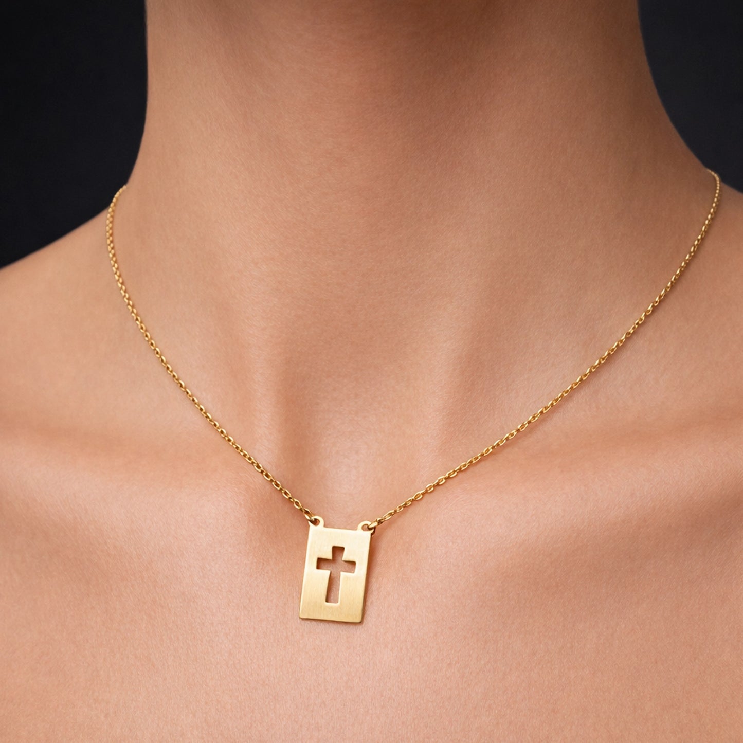 Gold cross cutout pendant necklace on delicate chain worn on natural skin model, minimalist Christian gold necklace, religious pendant jewelry, elegant faith necklace, modern gold cross jewelry close-up, dainty gold chain necklace, spiritual gift jewelry, studio lighting jewelry photo, luxury gold pendant necklace for women and men