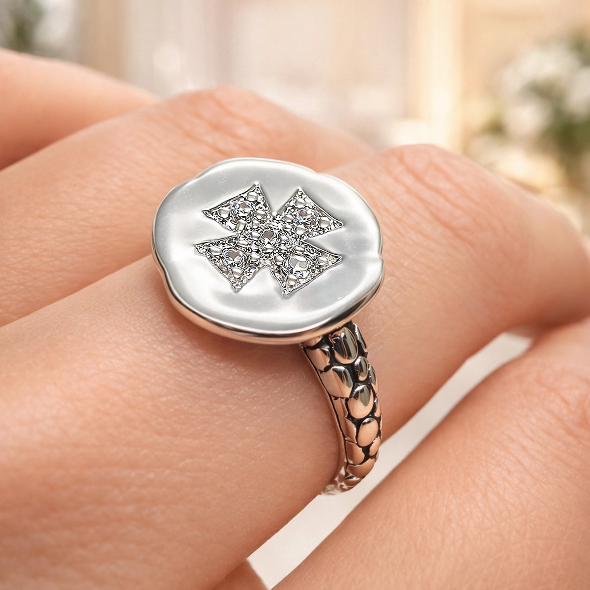 Sterling silver statement ring with textured snake-scale band and white enamel round top featuring a sparkling CZ Maltese cross design, worn on hand, elegant modern fashion jewelry.
