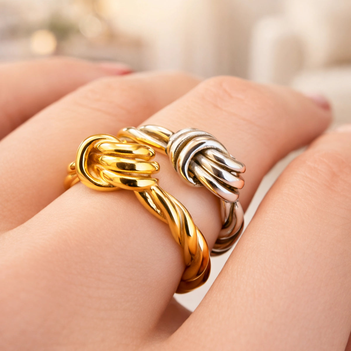 Gold and silver twisted knot rings on fingers, minimalist adjustable rope design rings, elegant modern statement rings, polished gold tone and silver tone jewelry, stylish everyday stacking rings for women.