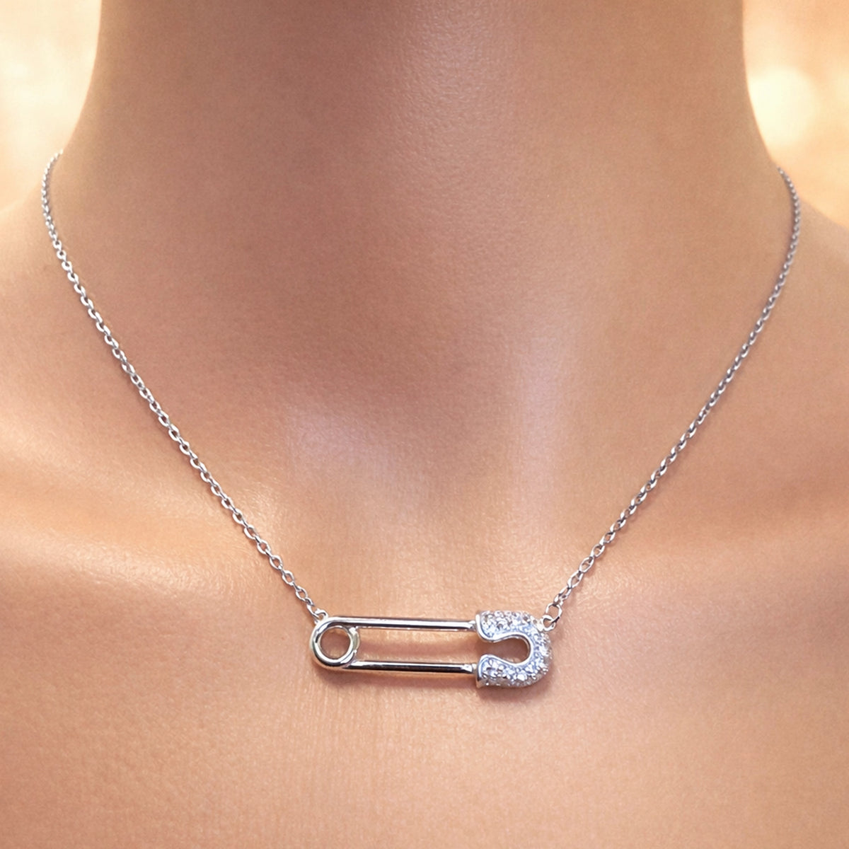 Silver Safety Pin Necklace with Rock Crystal Stones • Sterling Silver with Rhodium Plating • Minimalist Safety Pin Pendant on Delicate Chain • Modern Elegant Jewelry Close-Up on Model Neck • Sparkling Crystal Safety Pin Necklace