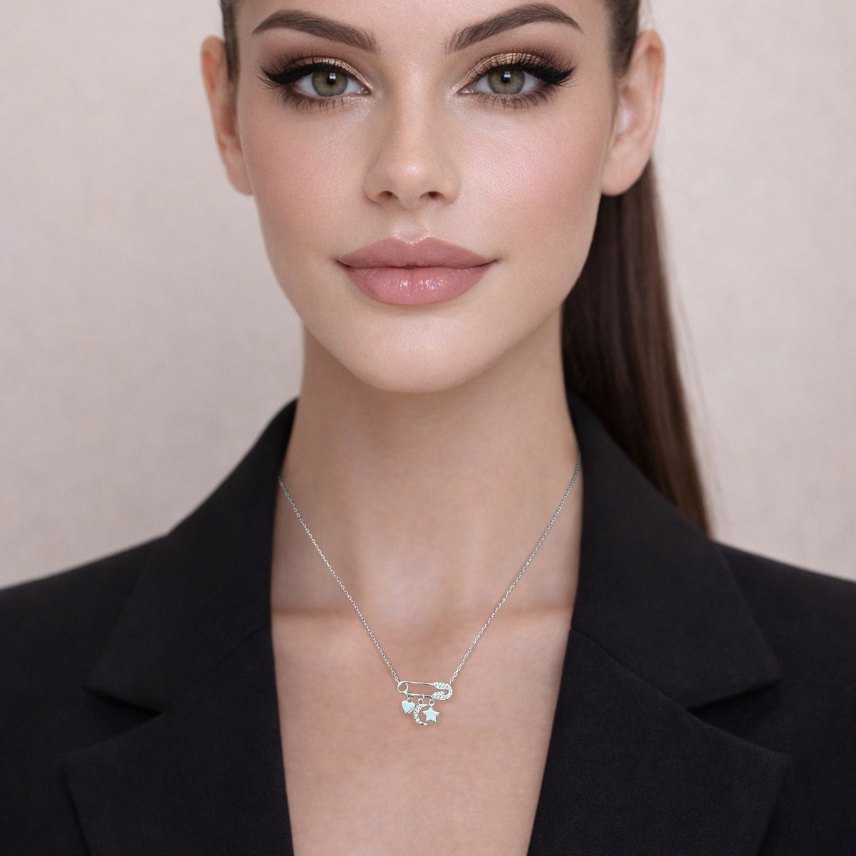 Model wearing dainty sterling silver safety pin necklace with CZ heart, moon, and star charms.