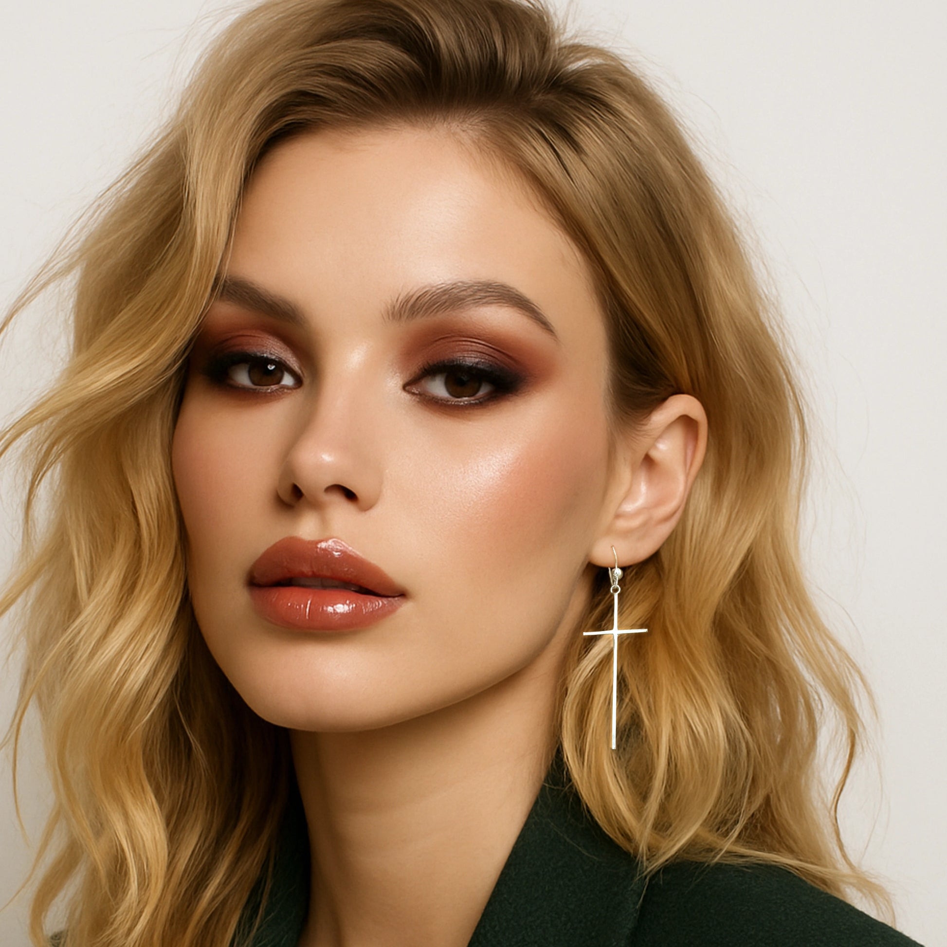 Elegant woman wearing sterling silver long cross drop earrings – religious statement jewelry with sleek modern design
